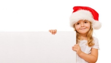 圣诞女孩扶着空白广告牌带圣诞帽的可爱小女孩图片