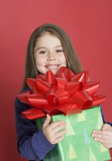 礼品与微笑抱着礼品盒的微笑小女孩图片