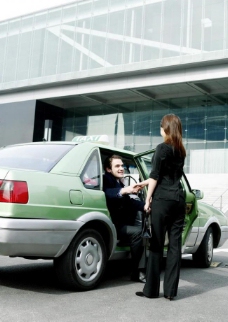 商务车边下出租车边握手的商务美女帅哥图片